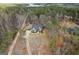 A charming home nestled among tall trees, featuring a long driveway and lake view at 172 Sam Solomon Rd, Locust Grove, GA 30248