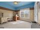 A serene bedroom with a large window, sewing table, neutral carpet, and a decorative paint scheme at 172 Sam Solomon Rd, Locust Grove, GA 30248