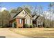 Side view of a brick and stone home with a driveway, garage, and manicured landscaping at 172 Sam Solomon Rd, Locust Grove, GA 30248