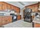 Well-lit kitchen features dark wood cabinets, tile floor, range, and black refrigerator at 439 Elder St, Fairburn, GA 30213