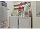 Efficient laundry area with washer, dryer, water heater, and shelving for ample storage, all in a compact space at 439 Elder St, Fairburn, GA 30213