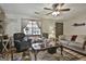 Comfortable living room featuring a ceiling fan, neutral colors, and a large ornate coffee table at 439 Elder St, Fairburn, GA 30213