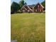 Charming two-story brick home with a well-manicured front lawn and mature trees at 65 Coldwater Way, Covington, GA 30016