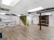 Spacious basement featuring a brick fireplace, stairs, and built-in shelving on light wood vinyl flooring at 434 Lees Lake Rd, Fayetteville, GA 30214