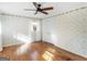 Inviting bedroom with decorative wallpaper, ceiling fan, hardwood floors and sunny windows at 434 Lees Lake Rd, Fayetteville, GA 30214