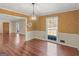 View of the dining room with hardwood floors, chandelier, and a large window bringing in natural light at 434 Lees Lake Rd, Fayetteville, GA 30214