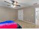 Neutral bedroom features a ceiling fan, carpet flooring, and double door closet at 2110 Mcgarity Rd, Mcdonough, GA 30252