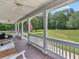 Covered porch with ceiling fan, white columns and railings, furniture, and an American flag at 2110 Mcgarity Rd, Mcdonough, GA 30252