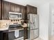 Modern kitchen with stainless steel appliances, dark wood cabinets, and a functional layout at 2110 Mcgarity Rd, Mcdonough, GA 30252