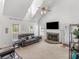 Bright living room featuring a vaulted ceiling, brick fireplace, and leather seating at 2110 Mcgarity Rd, Mcdonough, GA 30252