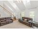 Large living room featuring a high ceiling, staircase, and comfortable leather sofas at 2110 Mcgarity Rd, Mcdonough, GA 30252