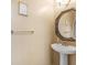 Powder Room featuring white pedestal sink, dark mirror, and gold accents at 2110 Mcgarity Rd, Mcdonough, GA 30252