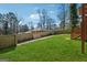 Spacious backyard featuring a green lawn, wooden fence, mature trees, and a deck at 2405 Hillside Ave, Decatur, GA 30032