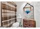 Modern bathroom featuring a stylish wood vanity with a glass sink, a patterned shower curtain, and white subway tile at 2405 Hillside Ave, Decatur, GA 30032