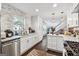 Charming white kitchen with marble countertops, a stainless steel dishwasher, and a view into the living area at 2405 Hillside Ave, Decatur, GA 30032