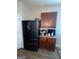 A kitchen area featuring a modern black refrigerator and upper and lower wood cabinets at 1687 Blue Heron Way, Hampton, GA 30228
