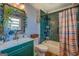 Stylish bathroom featuring green vanity and shower with green tile and decorated mirror at 3579 Bill Gardner Pkwy, Locust Grove, GA 30248