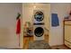 Efficient laundry area with stacked washer and dryer, and storage shelving at 3579 Bill Gardner Pkwy, Locust Grove, GA 30248