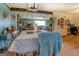 Cozy living room with beamed ceiling, fireplace, and dining area with decorative tablecloth at 3579 Bill Gardner Pkwy, Locust Grove, GA 30248
