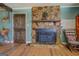 Living area with a striking stone fireplace, wooden door, and light-colored wood flooring at 3579 Bill Gardner Pkwy, Locust Grove, GA 30248