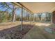View of a covered patio surrounded by mature trees and foliage at 3579 Bill Gardner Pkwy, Locust Grove, GA 30248