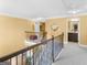 Upstairs hallway with wood and iron railing overlooking staircase at 108 Donovan Ave, Locust Grove, GA 30248