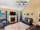 Cozy living room with brick fireplace, leather seating, ceiling fan and natural light from the windows at 108 Donovan Ave, Locust Grove, GA 30248