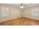 A bright bedroom featuring hardwood floors, neutral walls, and a ceiling fan at 437 Forrest Ave, Fayetteville, GA 30214