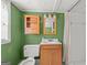 Charming bathroom with a wooden vanity, storage cabinet, and unique green wallpaper at 437 Forrest Avenue Ave, Fayetteville, GA 30214