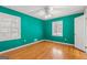 A bedroom with vibrant teal walls, hardwood floors and two windows at 437 Forrest Avenue Ave, Fayetteville, GA 30214