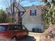 Two story home with attached two car garage, mature landscaping, and a driveway with an automobile at 2054 Gwinn Dr, Norcross, GA 30071