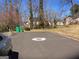 View of a quiet street with homes, mature trees, two green trash receptacles and an automobile at 2054 Gwinn Dr, Norcross, GA 30071