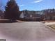 View of a quiet street with homes, mature trees and a wooden fence at 2054 Gwinn Dr, Norcross, GA 30071