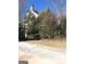 View of yard with mature landscaping, including trees and bushes with an asphalt road at 2054 Gwinn Dr, Norcross, GA 30071