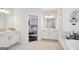 Bright white bathroom with double sinks and a luxurious soaking tub behind it at 401 Hallman Pl, Peachtree City, GA 30269