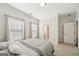 Neutral bedroom with a queen size bed, two windows, and a view into the en suite bath at 401 Hallman Pl, Peachtree City, GA 30269