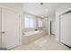 Bright bathroom with a soaking tub, tiled shower, and modern fixtures at 401 Hallman Pl, Peachtree City, GA 30269