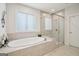 Bright bathroom features soaking tub, walk-in shower with glass door and tiled surround at 401 Hallman Pl, Peachtree City, GA 30269