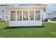 Exterior view of sunroom, with white siding and black mulch beds, visible from a well-manicured lawn at 401 Hallman Pl, Peachtree City, GA 30269