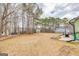 Large backyard with a wooden fence, large trees, and a small storage shed at 11157 Ash Ct, Hampton, GA 30228