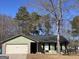 Cozy single-story home with stone accents, dark shutters, and green siding under a clear blue sky at 11157 Ash Ct, Hampton, GA 30228