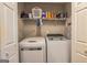 Functional laundry room with washer, dryer, and storage shelves for easy organization at 11157 Ash Ct, Hampton, GA 30228