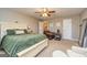 A roomy main bedroom with a ceiling fan, neutral walls and carpet, and a large bed at 11157 Ash Ct, Hampton, GA 30228