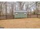 Charming backyard shed with a metal roof and double doors, surrounded by a wooden fence at 11157 Ash Ct, Hampton, GA 30228