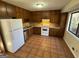 Functional kitchen with wooden cabinetry, tile floors, and white appliances at 2930 David Ne Ln, Conyers, GA 30012