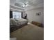 Spacious bedroom with tray ceilings, a ceiling fan, large window and an upholstered bench at 5725 Lake Windsor Pkwy, Buford, GA 30518