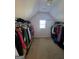 Attic closet with slanted ceilings, a window, and organized clothing racks at 5725 Lake Windsor Pkwy, Buford, GA 30518