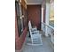 Close-up of front porch with white rocking chairs and brick facade for a relaxing outdoor experience at 5725 Lake Windsor Pkwy, Buford, GA 30518