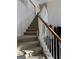 Carpeted staircase with white and wood railing leads to the second floor of the home at 5725 Lake Windsor Pkwy, Buford, GA 30518