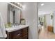 Bathroom with wooden vanity and mirror, next to bedroom area with sliding glass doors and a walk-in closet at 62 Cobblestone Crk, Peachtree City, GA 30269